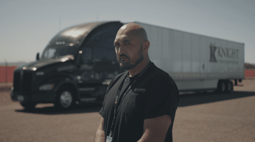Owner Operator Truck Driver standing in front of a Knight Transportation truck